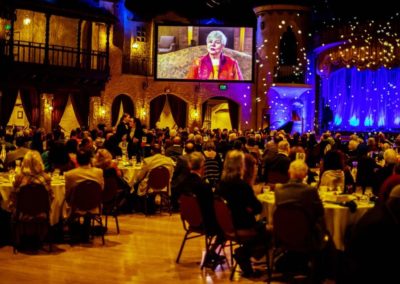 2020 Interfaith Ambassador Betty Brandt on the screen at the 6th Annual Interfaith Banquet